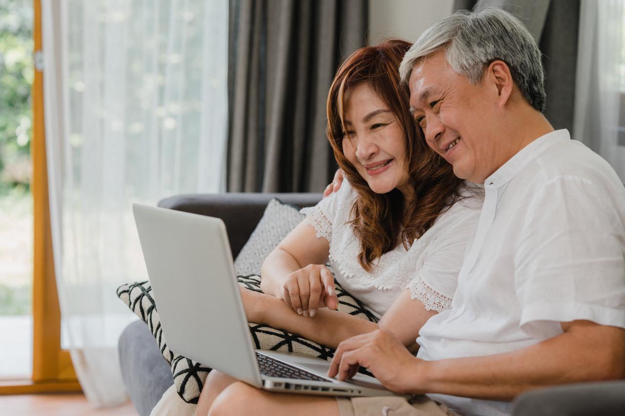 A senior asian couple is looking at a laptop