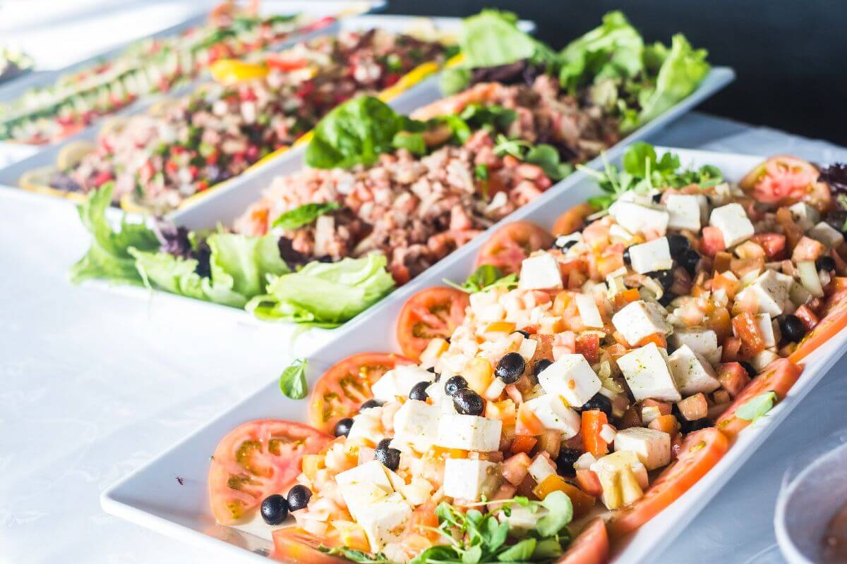 Fresh buffet catering spread with salads, vegetables, and gourmet party food selections.