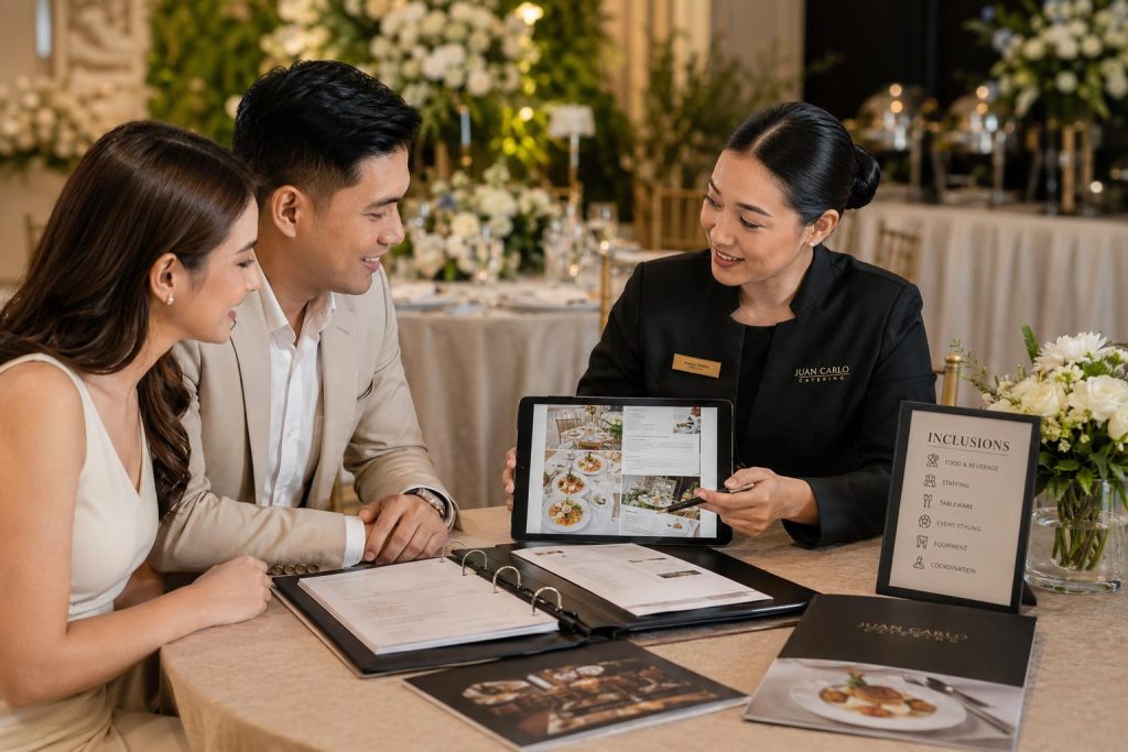 Couple reviews catering package inclusions with a Juan Carlo representative at an elegant event setup