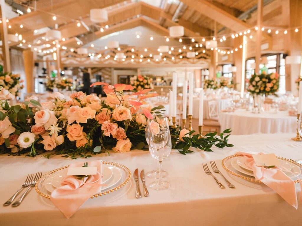 Classic wedding table setup with floral arrangements, soft lighting, and elegant place settings